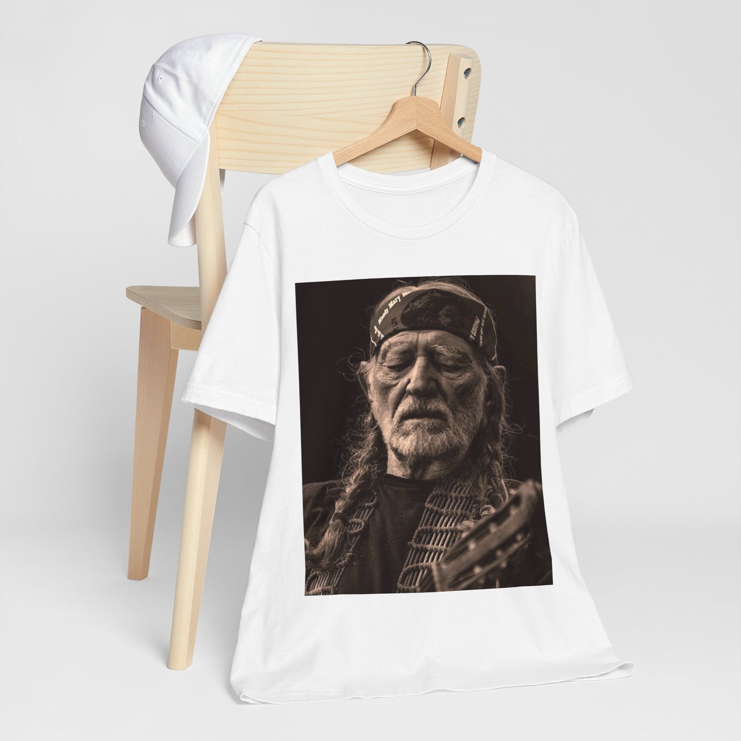 A black graphic t-shirt featuring a graphic of Willie Nelson with his iconic braids style.