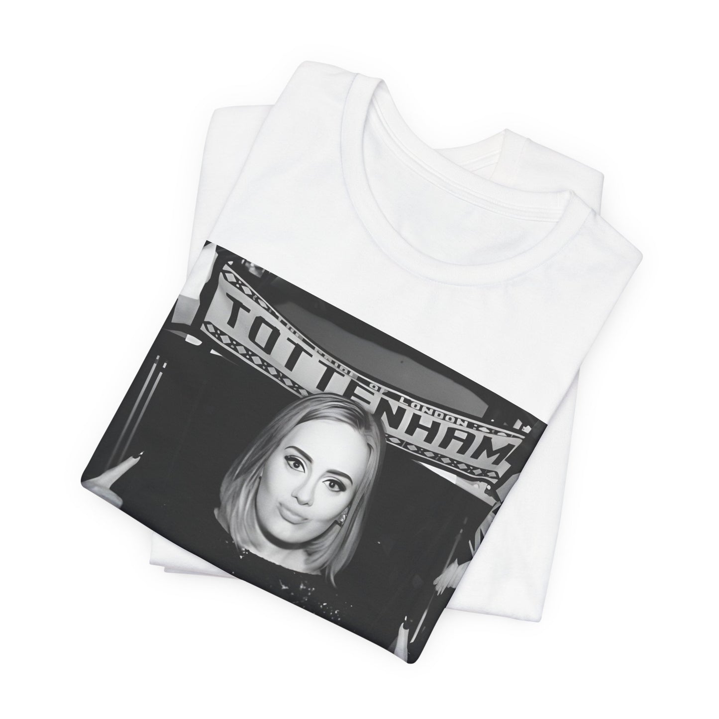 A black graphic t-shirt featuring a photo of Adele in a casual setting, surrounded by fans at a Tottenham event, showing her smiling or interacting.