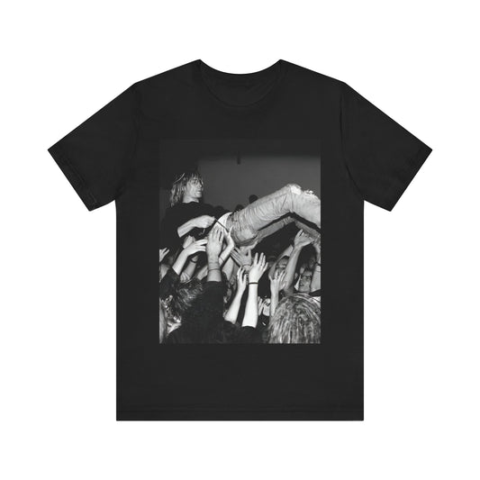 A black graphic t-shirt featuring a 90s graphic or photo of Kurt Cobain from Nirvana stage diving.