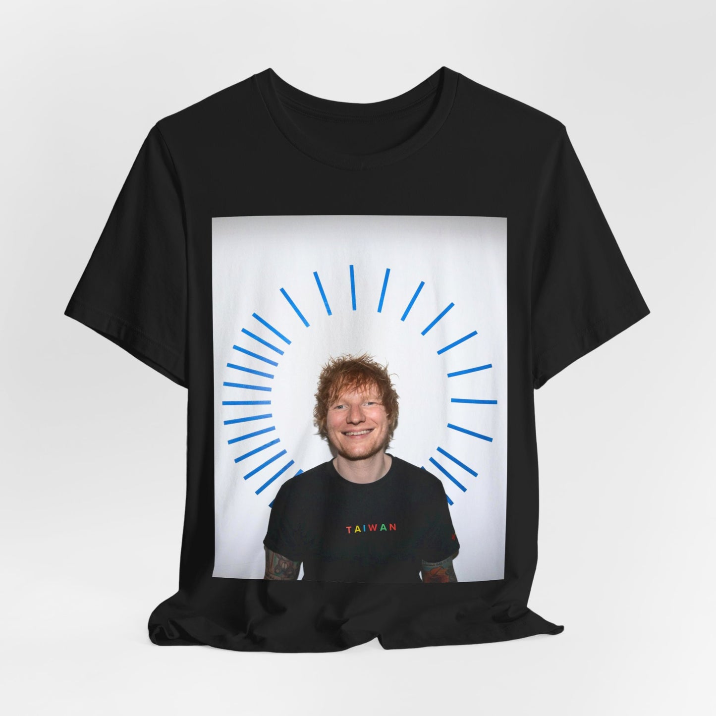 A black graphic t-shirt featuring a classic photo portrait of Ed Sheeran in a folk-pop style.