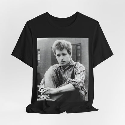 A black graphic t-shirt featuring a graphic of Bob Dylan from his 60s origins in folk music.