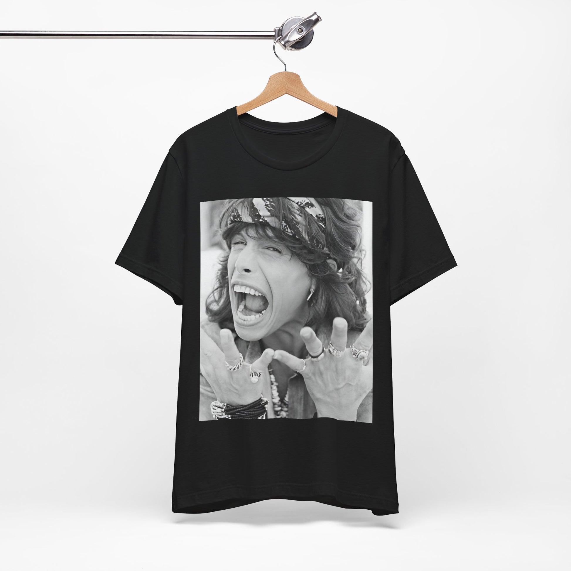 A black graphic t-shirt featuring a candid, dynamic photo of Aerosmith band members on tour in the 1970s, possibly showing action or interaction on stage or backstage.