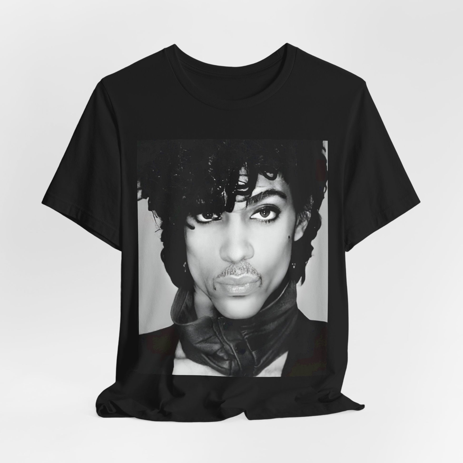 A black graphic t-shirt featuring a black and white photo portrait of Prince.