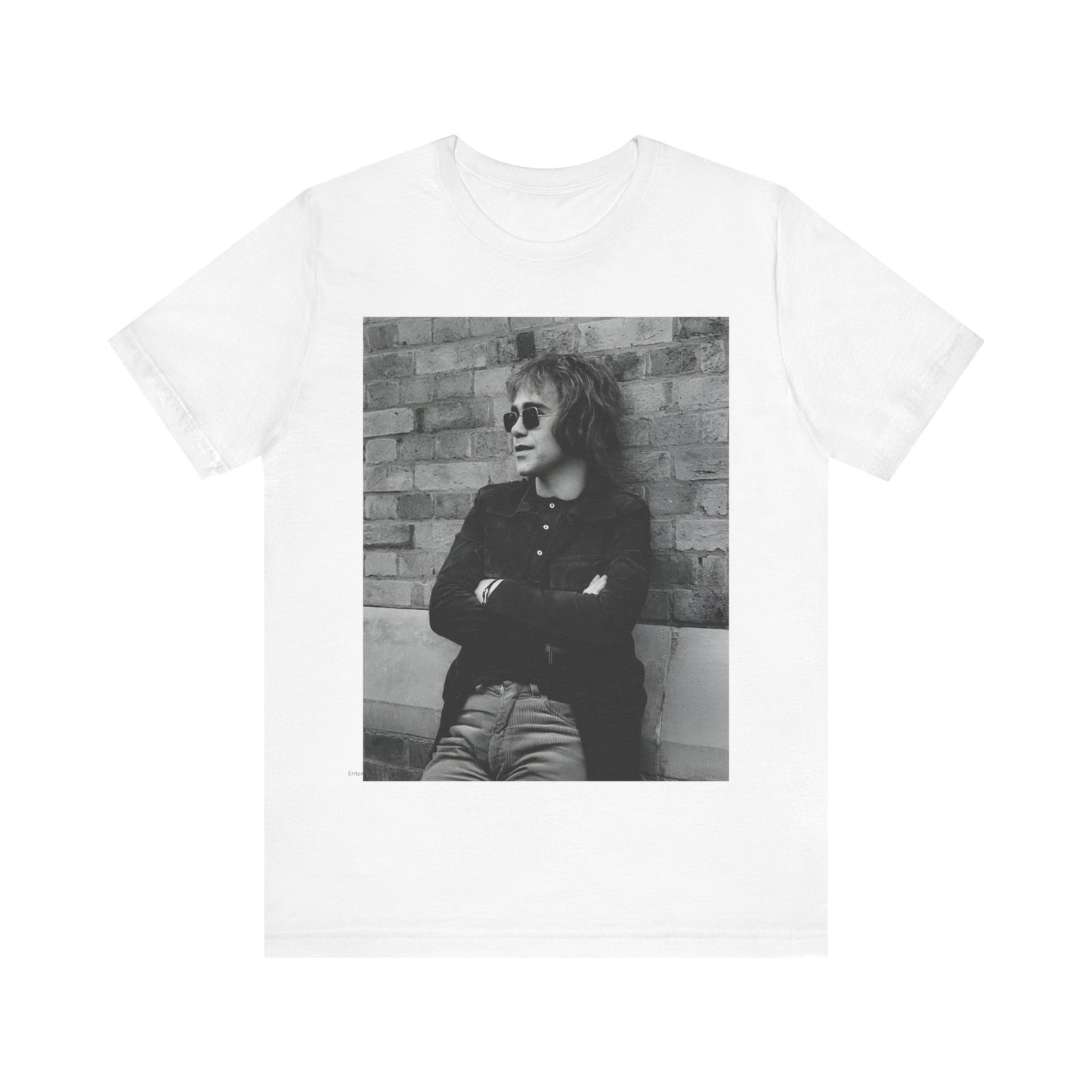 A black graphic t-shirt featuring a vintage graphic related to Elton John's 'Farewell Yellow Brick Road' tour.