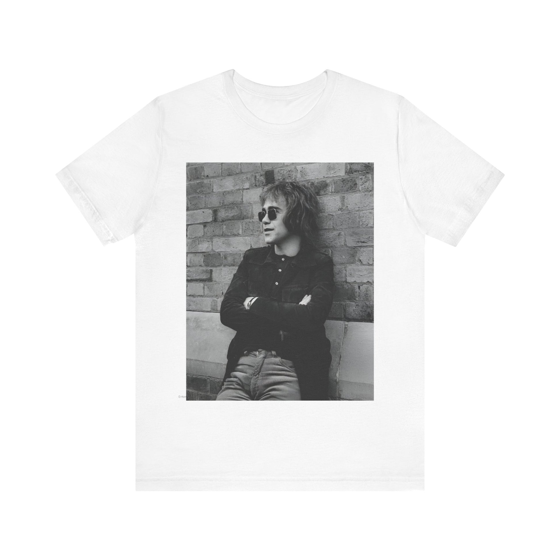 A black graphic t-shirt featuring a vintage graphic related to Elton John's 'Farewell Yellow Brick Road' tour.