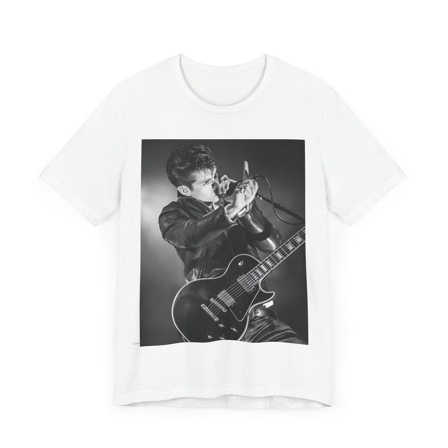 A black graphic t-shirt featuring a dynamic black and white graphic or photo of Arctic Monkeys performing live, emphasizing energy.