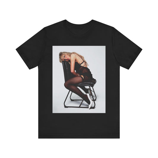 A black graphic t-shirt featuring a playful pop art style graphic of Sabrina Carpenter.