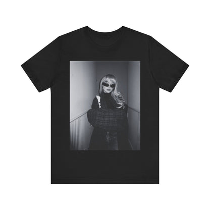 A black graphic t-shirt featuring a black and white glam pop diva graphic of Sabrina Carpenter.
