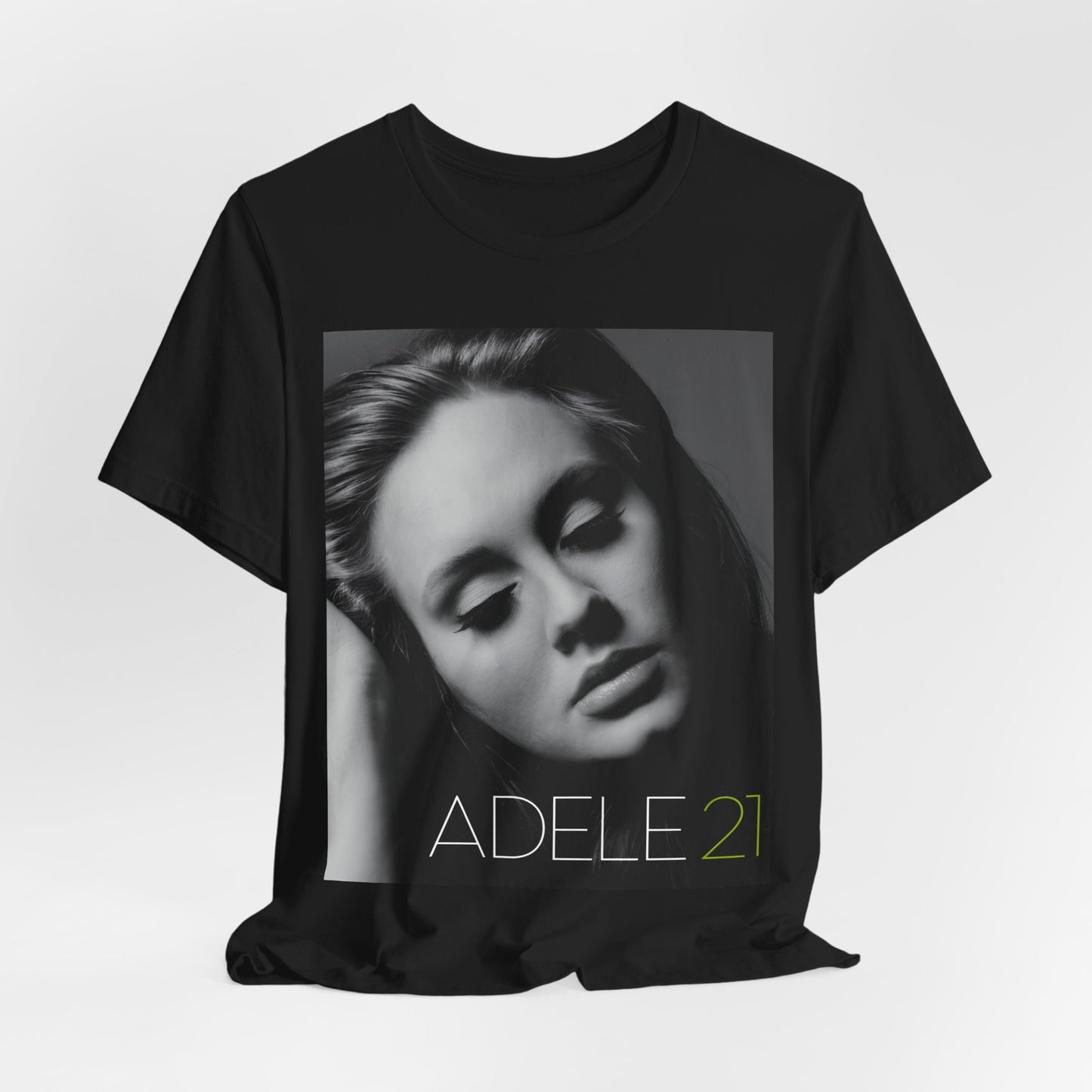 A black graphic t-shirt featuring the album cover art for Adele's '21' album, showing a close-up portrait of her with a contemplative expression.