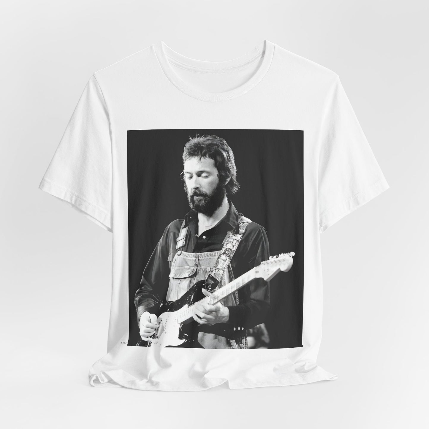 A black graphic t-shirt featuring a graphic or photo of Eric Clapton performing live on stage with his guitar.