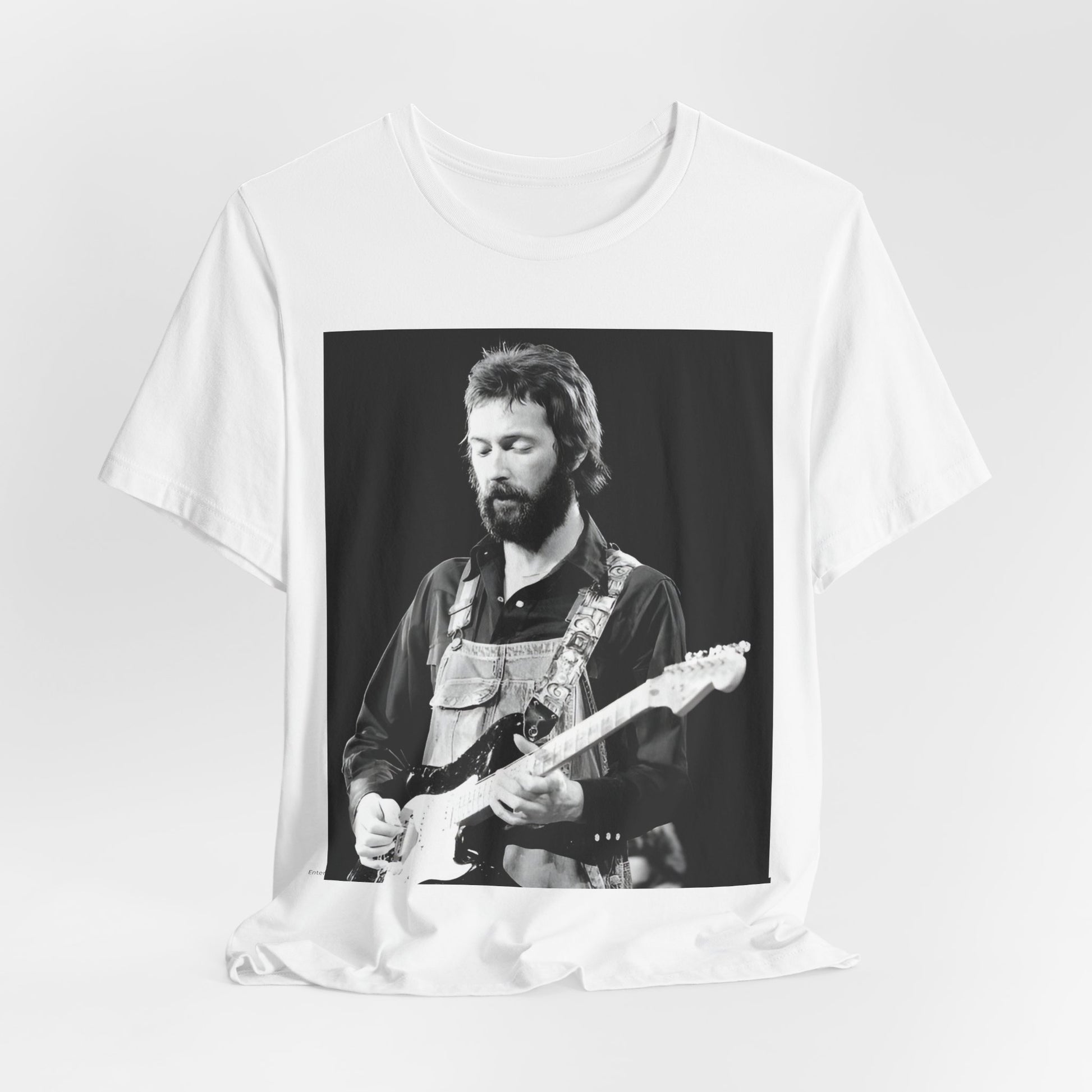 A black graphic t-shirt featuring a graphic or photo of Eric Clapton performing live on stage with his guitar.