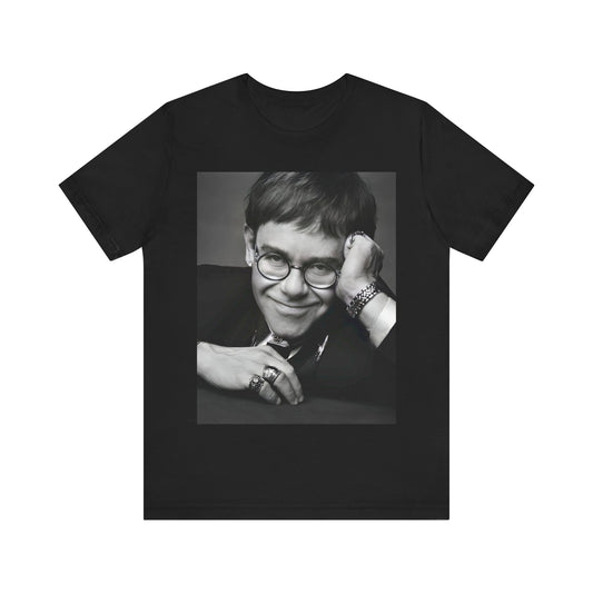 A black graphic t-shirt featuring a retro black and white photo portrait of Elton John.