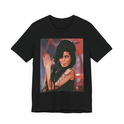A black graphic t-shirt featuring a photo of Amy Winehouse performing live on stage in 2008, with her signature beehive and expressive singing.