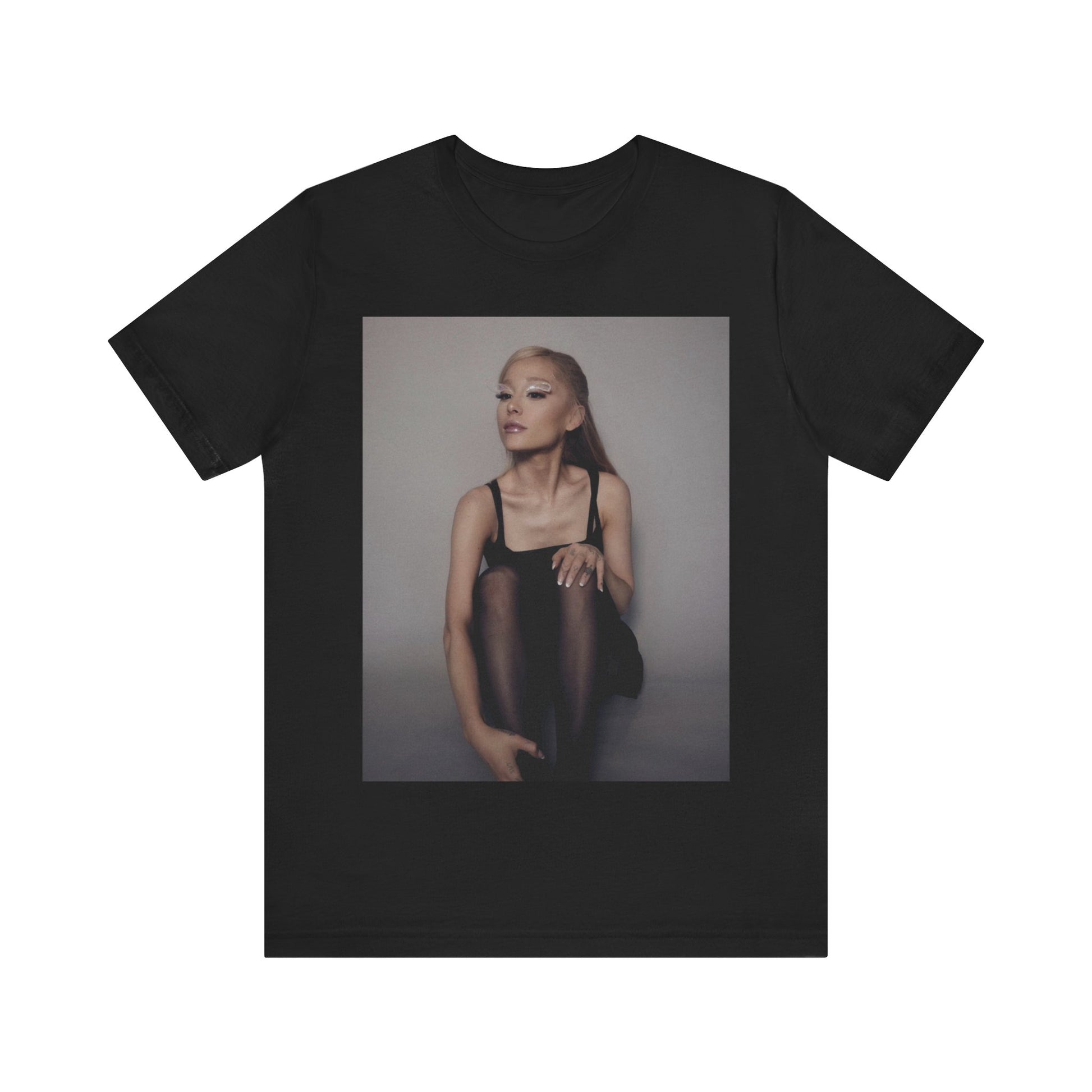 A black graphic t-shirt featuring a bold and beautiful graphic of Ariana Grande, emphasizing her strong and confident presence.