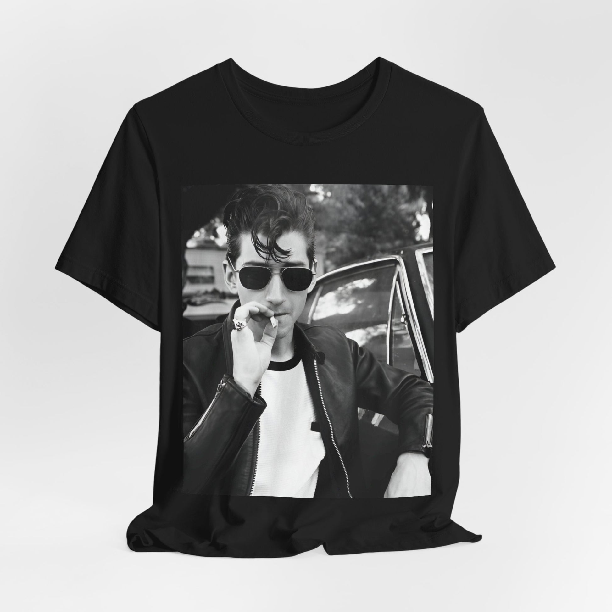 A black graphic t-shirt featuring a classic rock-style graphic of the Arctic Monkeys, possibly with band members in a stylized design.