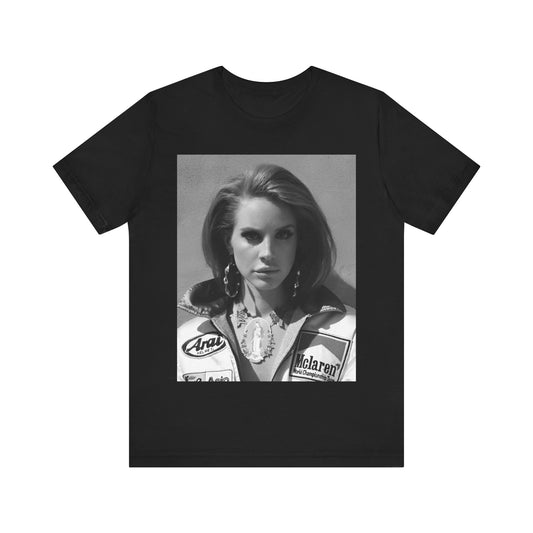 Black and white photo of Lana Del Rey wearing a vintage racing jacket with motorsport patches, printed on a graphic t-shirt.