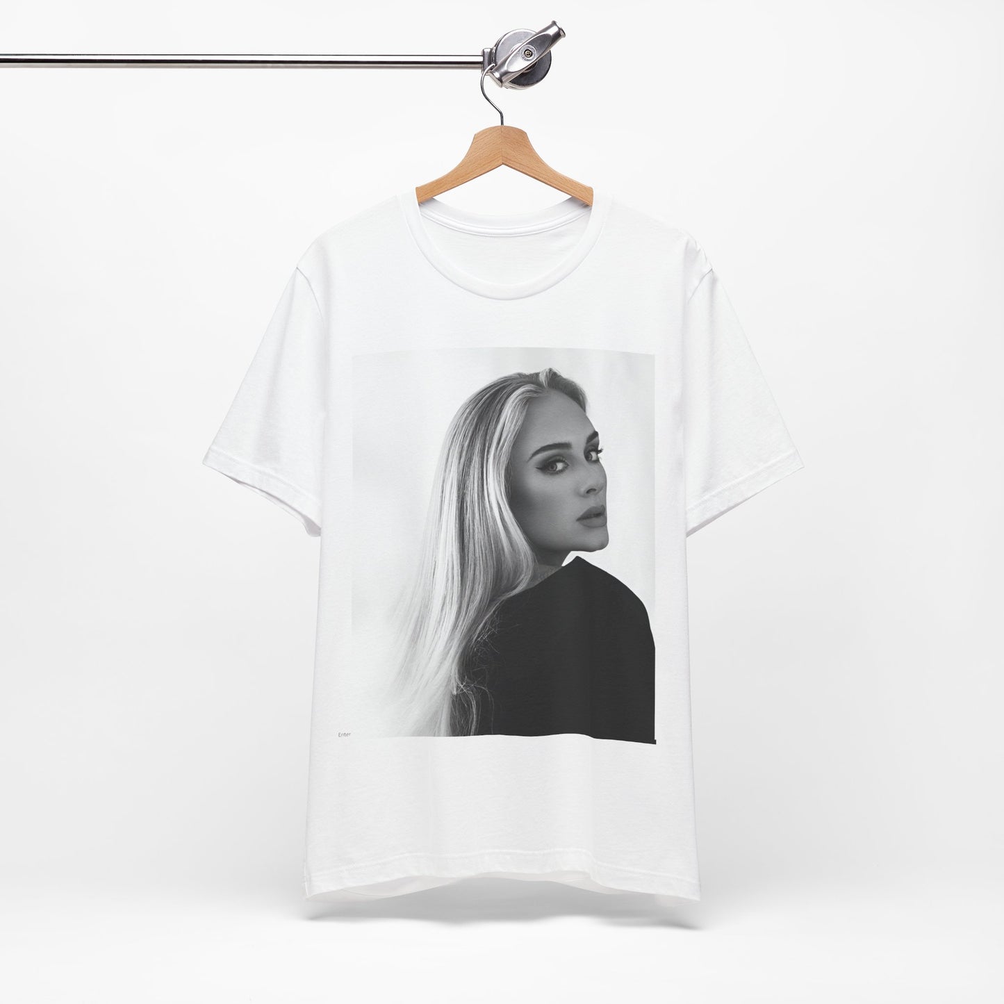 A black graphic t-shirt featuring a black and white, monochromatic portrait of Adele, showing her with a serene or thoughtful expression.