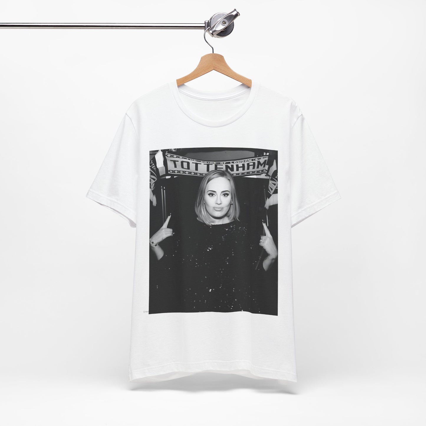 A black graphic t-shirt featuring a photo of Adele in a casual setting, surrounded by fans at a Tottenham event, showing her smiling or interacting.