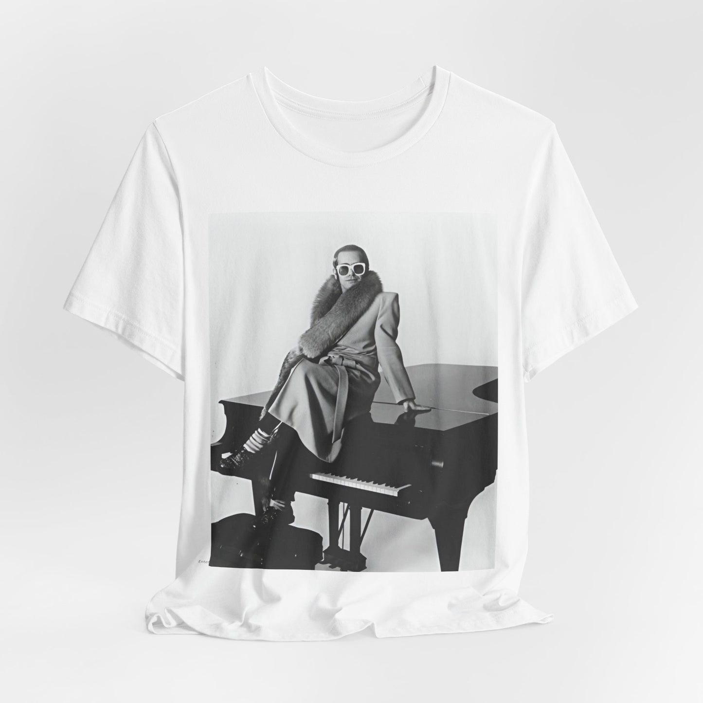 A black graphic t-shirt featuring a black and white photo of Elton John playing the piano.